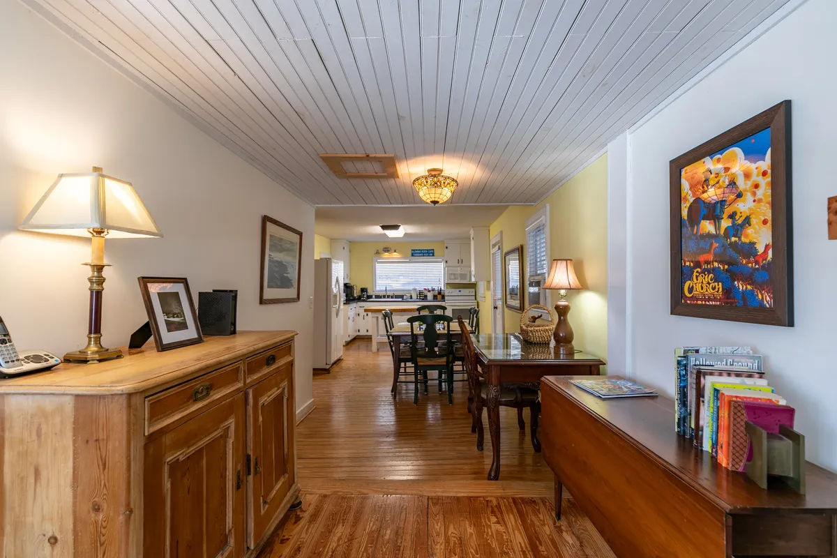 A warm, cozy interior dining space with rich wooden furniture, a classic chandelier, and tasteful artwork adorning the walls. The room exudes a sense of history and comfort, inviting guests to share meals, socialize, and relax together after a day out.